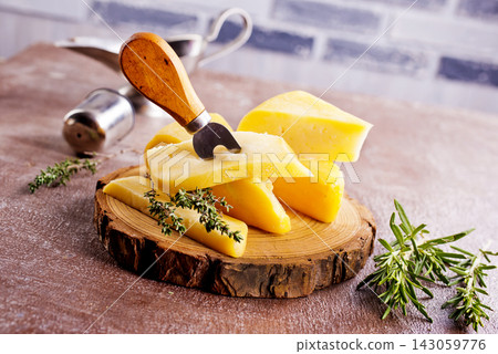 Plate and board with pieces of Swiss cheese on a table Plate and board with pieces of Swiss cheese on a table 143059776