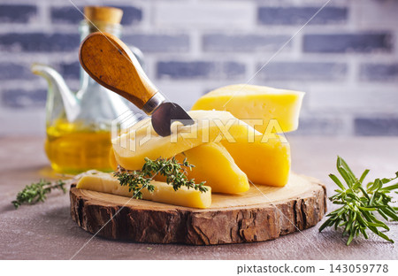 Plate and board with pieces of Swiss cheese on a table Plate and board with pieces of Swiss cheese on a table 143059778