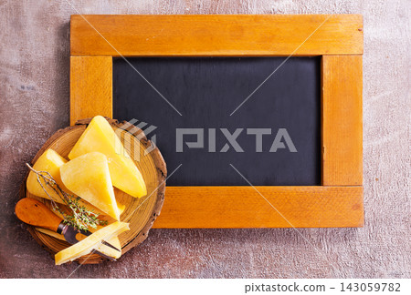 Plate and board with pieces of Swiss cheese on a table Plate and board with pieces of Swiss cheese on a table 143059782