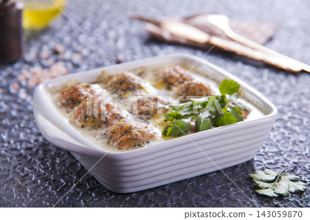 Thai pork meatballs with a spicy dipping sauce, served on a white plate. Stock Photo Thai pork meatballs with a spicy dipping sauce, served on a white plate. Stock Photo 143059870