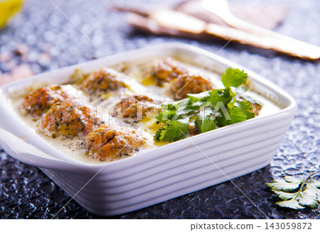 Thai pork meatballs with a spicy dipping sauce, served on a white plate. Stock Photo Thai pork meatballs with a spicy dipping sauce, served on a white plate. Stock Photo 143059872