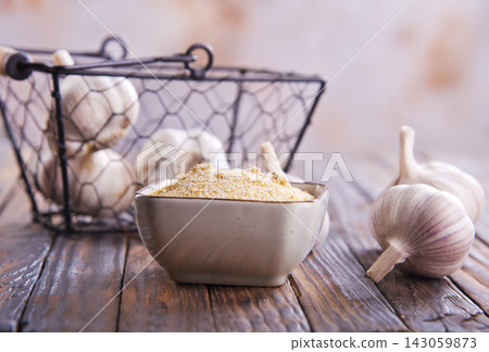 Ginger powder in a bowl, surrounded by garlic cloves Ginger powder in a bowl, surrounded by garlic cloves 143059873