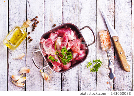 fresh meat in metal bowl, raw meat with greens and spice on a table 143060088