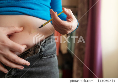 Woman receiving weight loss injections and fat dissolving injections into belly fat at home. Close up of stomach subcutaneous injection, lipolytic, fertility hormone, or insulin therapy. Woman receiving weight loss injections and fat dissolving injections into belly fat at home. Close up of stomach subcutaneous injection, lipolytic, fertility hormone, or insulin therapy. 143060214