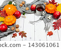 Bright fall horizontal background with orange pumpkins and red apples, nuts,cup of tea,green and yellow leaves and scarf,lying on the white desk wood with empty place for your text,perspective view 143061061