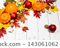 Bright autumn horizontal background with orange pumpkins and red apples, nuts, green and yellow leaves and scarf, lying on the white desk wood wih empty place for your text. Perspective side view. 143061062