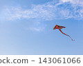 Simple laconic background with rainbow kite flying in the blue sky with empty place for your text 143061066