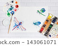 Hand Drawn Bright Sketch of Blue, Green and Violet Dragonflies, with lying paints, paintbrushes and palette on the white brick background - concept of human creativity, flat top view 143061071