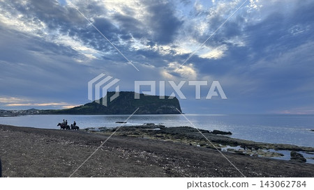 在城山日出峰下方的廣治峽海灘上騎馬的人們 在城山日出峰下方的廣治峽海灘上騎馬的人們 143062784
