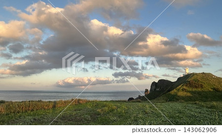 濟州島涉地岬燈塔和海上的金色雲朵。 濟州島涉地岬燈塔和海上的金色雲朵。 143062906