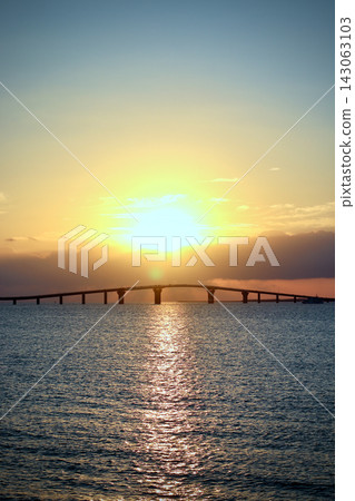 夕陽西下,大海泛著金色的光芒,一座大橋橫跨地平線。 夕陽西下,大海泛著金色的光芒,一座大橋橫跨地平線。 143063103