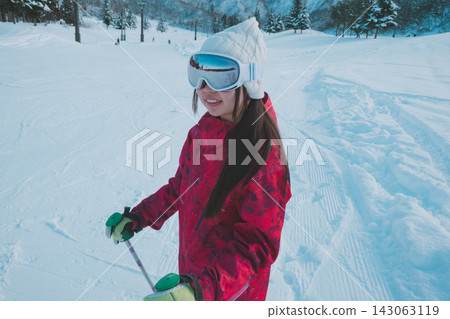 一名高中女生在滑雪道上側頭微笑。 143063119