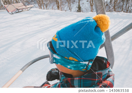 一個男孩正在乘坐滑雪纜車 一個男孩正在乘坐滑雪纜車 143063538
