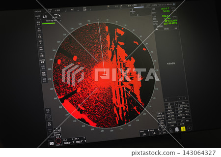 Maritime radar screen on a ship bridge displaying dense red echoes 143064327