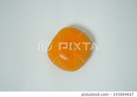High-resolution stock image that can be used as a photograph of a single persimmon placed in the center of a white background, bottom side up. High-resolution stock image that can be used as a photograph of a single persimmon placed in the center of a white background, bottom side up. 143064687