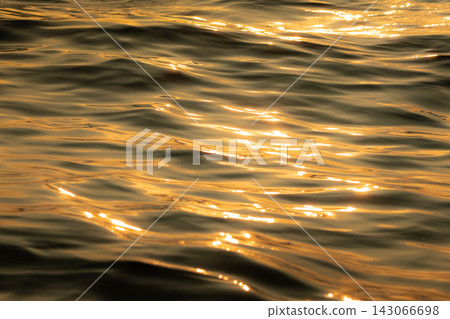 金色的光芒灑在平靜的海面上。 143066698