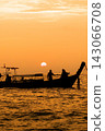A long-tailed boat and human figures floating in the Thai sunset. 143066708