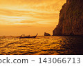 The cliffs of the Phi Phi Islands and the long-tailed boat at sunset. 143066713