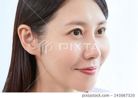 A woman smiles and shows off the results after getting an eyelash perm. A woman smiles and shows off the results after getting an eyelash perm. 143067320