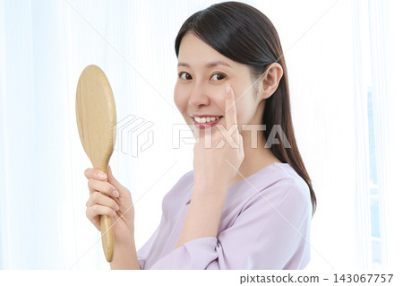 A woman who looks in the mirror and smiles A woman who looks in the mirror and smiles 143067757