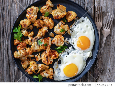 Baked crispy cauliflower served with fried eggs Baked crispy cauliflower served with fried eggs 143067783