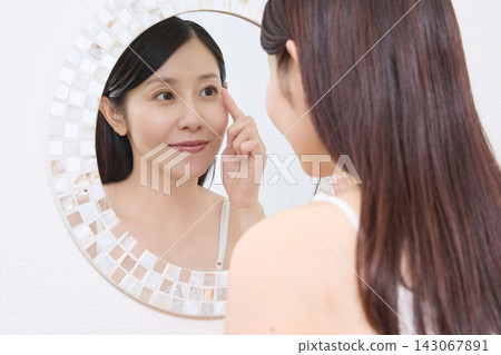 一位女士對著鏡子查看她燙睫毛的效果(圖片由Makanaani提供) 一位女士對著鏡子查看她燙睫毛的效果(圖片由Makanaani提供) 143067891