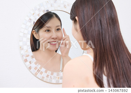 一位女士對著鏡子查看她燙睫毛的效果(圖片由Makanaani提供) 一位女士對著鏡子查看她燙睫毛的效果(圖片由Makanaani提供) 143067892