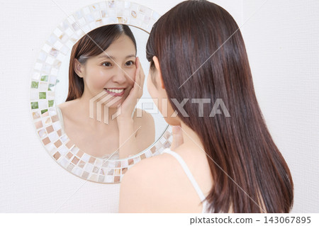 一位女士對著鏡子查看她燙睫毛的效果(圖片由Makanaani提供) 一位女士對著鏡子查看她燙睫毛的效果(圖片由Makanaani提供) 143067895