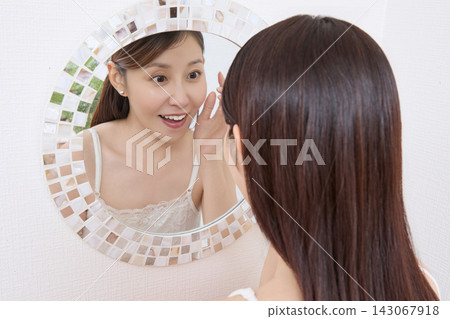 一位女士對著鏡子查看她燙睫毛的效果(圖片由Makanaani提供) 一位女士對著鏡子查看她燙睫毛的效果(圖片由Makanaani提供) 143067918