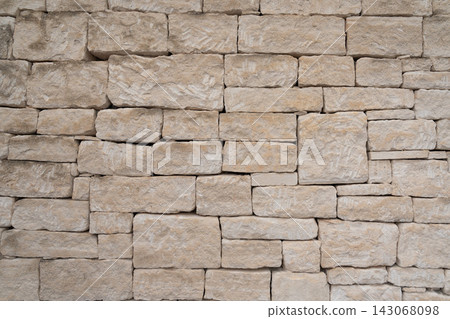 Weathered limestone wall built from rough hand cut stone blocks 143068098