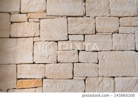 Traditional limestone wall featuring rough blocks and natural stone texture Traditional limestone wall featuring rough blocks and natural stone texture 143068100