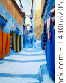 Chefchaouen Blue alley with hanging colorful textiles 143068205