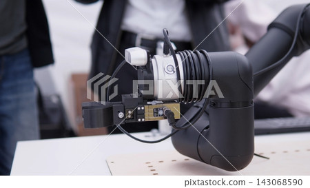 Close up shows industrial robotic arm with cable wrapped joint, precision gripper, control module, and connected sensors, displayed in bright modern technical environment for automation, robotics Close up shows industrial robotic arm with cable wrapped joint, precision gripper, control module, and connected sensors, displayed in bright modern technical environment for automation, robotics 143068590