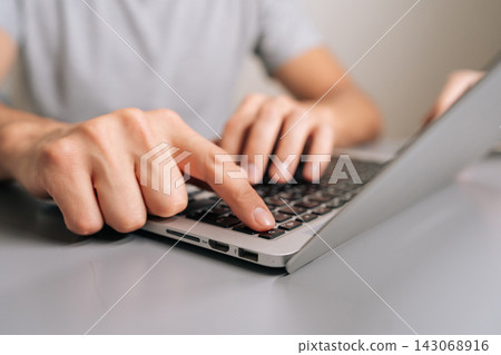 Finger pressing laptop power button, initiating startup sequence, switching on computing device, turning on technology for working, learning, or connecting. Finger pressing laptop power button, initiating startup sequence, switching on computing device, turning on technology for working, learning, or connecting. 143068916
