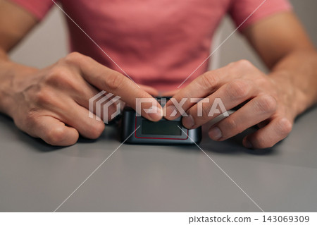 User hands preparing to charge electronic device batteries, unboxing camera power adapter, placing charger on grey table, offering continuous power solution for photography equipment. User hands preparing to charge electronic device batteries, unboxing camera power adapter, placing charger on grey table, offering continuous power solution for photography equipment. 143069309