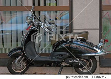 The scooter is parked at the shop 143069470