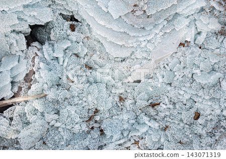 Shattered glass fragments and broken automotive safety glass pieces cover the ground in an abstract texture background Shattered glass fragments and broken automotive safety glass pieces cover the ground in an abstract texture background 143071319
