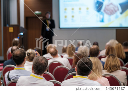 Conference presentation with a handshake image on screen 143071387