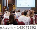 Conference attendee photographing a presentation with a smartphone 143071392