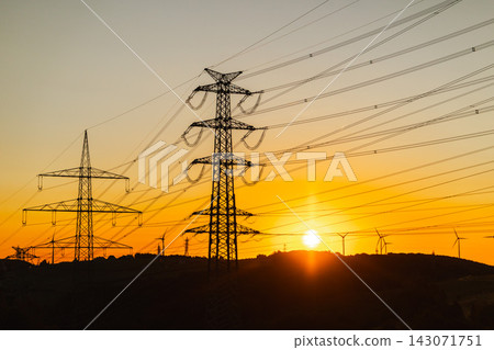 Electricity Transmission Pylons and Wind Turbines at Sunset Electricity Transmission Pylons and Wind Turbines at Sunset 143071751