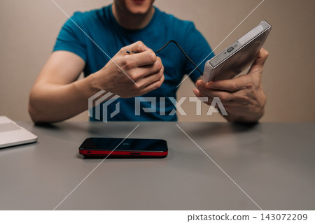 Person connecting a usb cable into a portable external optical disc drive for data transfer and media playback on modern laptops. 143072209