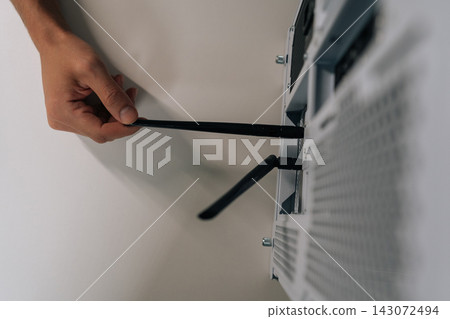 Close-up top view of technician hand installing network antenna into desktop computer, establishing wireless internet connection for device and enabling high-speed data transfer. 143072494