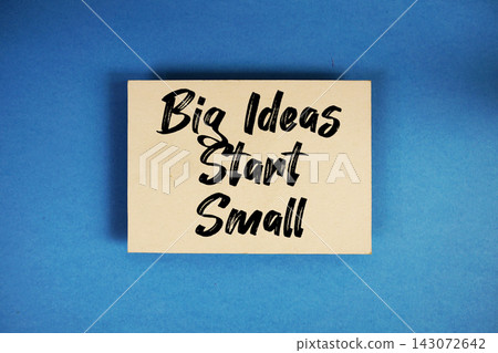 Big Ideas Start Small text written on paper card top view on blue background Big Ideas Start Small text written on paper card top view on blue background 143072642