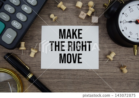 Make The Right Move text written on notepad with pen, alarm clock, magnifying glass and calculator on wooden background 143072875