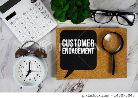Customer Engagement text with calculator and magnifying glass on marble background Customer Engagement text with calculator and magnifying glass on marble background 143073043