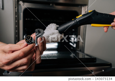 Hands holding old and new brush demonstrating wear of cleaning accessories, emphasizing need for replacement during deep cleaning of kitchen oven with steam appliance. Hands holding old and new brush demonstrating wear of cleaning accessories, emphasizing need for replacement during deep cleaning of kitchen oven with steam appliance. 143073134