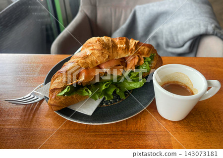 a plate of sandwich  with a sandwich and a cup of coffee 143073181