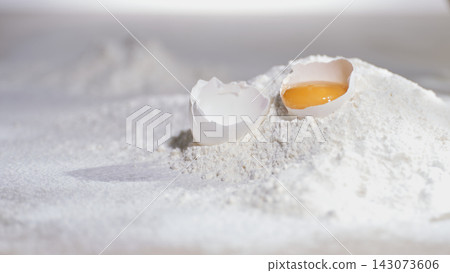 Egg yolk sits on white flour in a kitchen Egg yolk sits on white flour in a kitchen 143073606