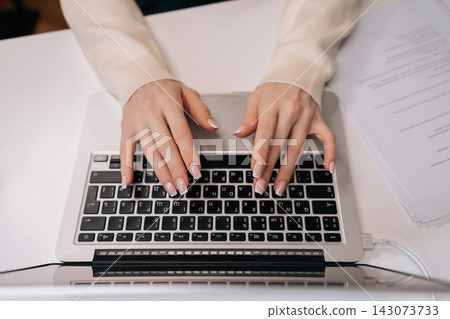 Top view of businesswoman hands typing on laptop keyboard, engaging in remote work, online education, digital communication, utilizing modern technology for business tasks and personal connection. Top view of businesswoman hands typing on laptop keyboard, engaging in remote work, online education, digital communication, utilizing modern technology for business tasks and personal connection. 143073733