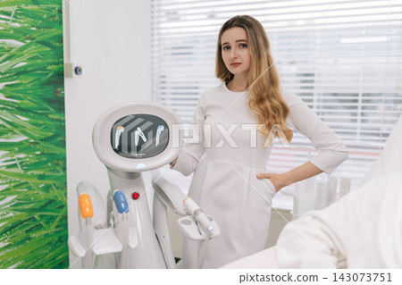 Portrait of professional cosmetologist standing in modern beauty clinic, showcasing advanced SMAS lifting technology for skin rejuvenation and anti-aging treatments, offering expert aesthetic services Portrait of professional cosmetologist standing in modern beauty clinic, showcasing advanced SMAS lifting technology for skin rejuvenation and anti-aging treatments, offering expert aesthetic services 143073751